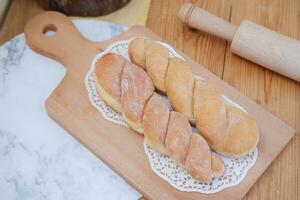 Bread donuts on the wooden table with wooden rolling pin. photo