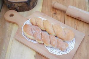 Bread donuts on the wooden table with wooden rolling pin. photo