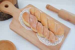 Bread donuts on the wooden table with wooden rolling pin. photo