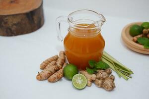Ginger juice with fresh ginger and lemon on white background. Healthy drink. photo
