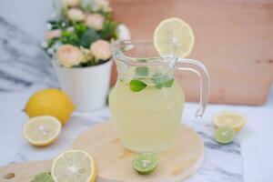 Lemonade with fresh lemon and mint leaves on a white background photo