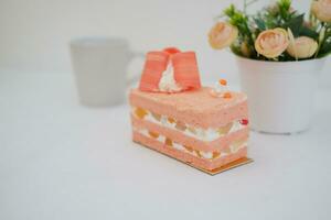 Piece of cake and cup of tea on white background, stock photo