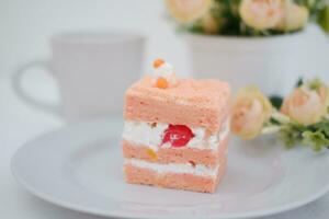Piece of cake and cup of tea on white background, stock photo