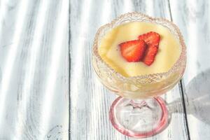 Sabayon with strawberry slices on the wooden background photo