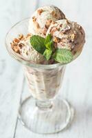vainilla-chocolate hielo crema en un helado con frutas y nueces vaso foto