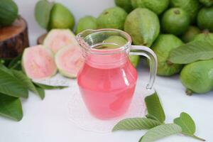 Fresco guayaba jugo en un vaso y Fresco guayaba fruta. foto