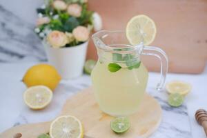 Lemonade with fresh lemon and mint leaves on a white background photo