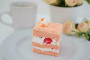 Piece of cake and cup of tea on white background, stock photo