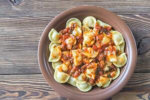 Portion of ravioli with marinara sauce photo