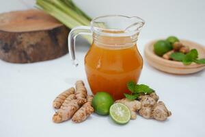 Ginger juice with fresh ginger and lemon on white background. Healthy drink. photo