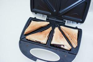 Toaster with toasted bread and chocolate in a white kitchen. photo