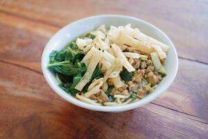 Fried noodle in white bowl on wooden table photo