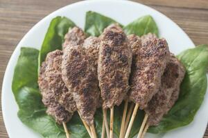 Beef cabobs on the fresh spinach leaves photo