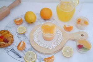 Fresh orange juice in glass and fresh citrus fruits on white background. photo