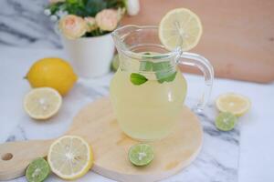 Lemonade with fresh lemon and mint leaves on a white background photo