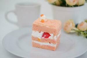 Piece of cake and cup of tea on white background, stock photo