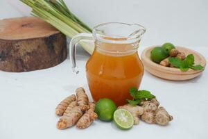 Ginger juice with fresh ginger and lemon on white background. Healthy drink. photo