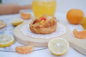 Homemade lemon tart with fresh fruit and orange juice on white background photo