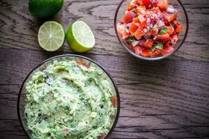 Bowls of guacamole and salsa photo