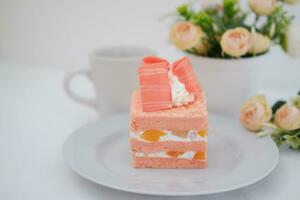 Piece of cake and cup of tea on white background, stock photo