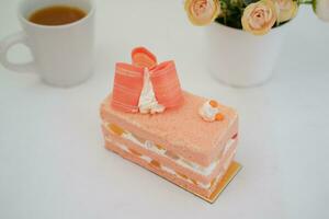 Piece of cake and cup of tea on white background, stock photo