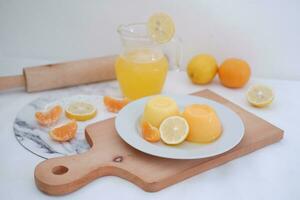 Orange jelly with fresh lemon and orange juice on a white background. photo