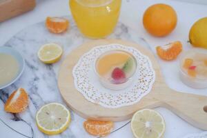 Fruta jalea con naranja jugo, limón y kiwi en el mesa foto