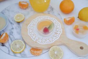 Fruit jelly with orange juice, lemon and kiwi on the table photo