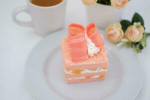 Piece of cake and cup of tea on white background, stock photo