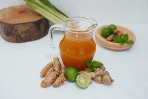 Ginger juice with fresh ginger and lemon on white background. Healthy drink. photo