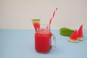 Watermelon smoothie in a glass jar with straws as a background photo