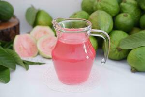 Fresco guayaba jugo en un vaso y Fresco guayaba fruta. foto