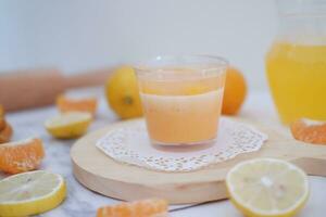 Fresh orange juice in glass and fresh citrus fruits on white background. photo