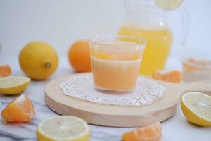 Fresh orange juice in glass and fresh citrus fruits on white background. photo