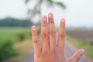 Close-up of human hand on blur nature background. Copy space photo