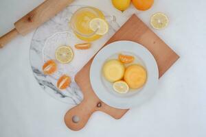 Orange jelly with fresh lemon and orange juice on a white background. photo