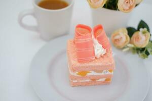 Piece of cake and cup of tea on white background, stock photo