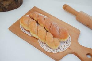 Bread donuts on the wooden table with wooden rolling pin. photo