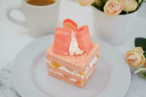 Piece of cake and cup of tea on white background, stock photo