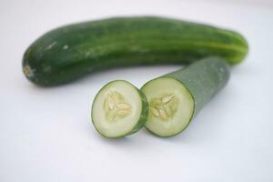 Pepino y rebanadas en un blanco antecedentes. selectivo enfocar. foto