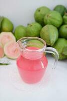 Fresh guava juice in a glass and fresh guava fruit. photo