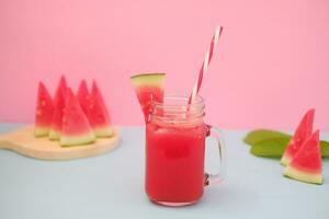 Watermelon smoothie in a glass jar with straws as a background photo