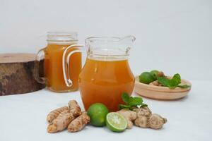 Ginger juice with fresh ginger and lemon on white background. Healthy drink. photo