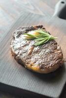 Beef steak with fresh rosemary on the wooden board photo