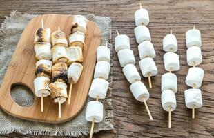 brochetas de malvavisco en la tabla de madera foto