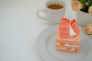 Piece of cake and cup of tea on white background, stock photo