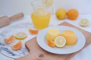 Orange jelly with fresh lemon and orange juice on a white background. photo