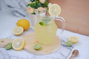 Lemonade with fresh lemon and mint leaves on a white background photo