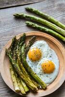 Roasted asparagus with fried eggs photo