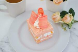 Piece of cake and cup of tea on white background, stock photo